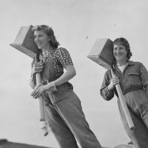 Two female builders carry hods of bricks on a building site, 1941 © Imperial War Museum